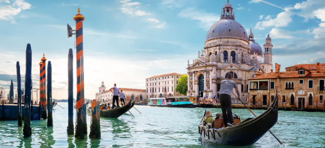 Gran Canale a Venezia con gondole e la Basilica di Santa Maria della Salute, cielo soleggiato